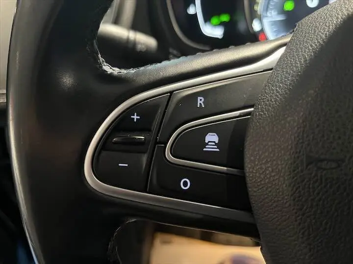 Gros plan sur les commandes au volant du Renault Scénic IV DCI 160 Energy, avec boutons de régulateur et aide à la conduite.