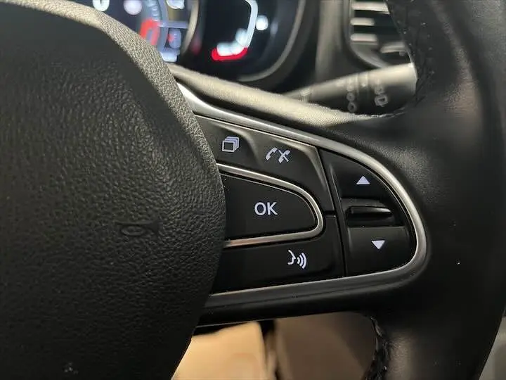 Gros plan sur les commandes multifonctions à droite du volant noir du Renault Scenic IV DCI 160 Energy EDC Intens.