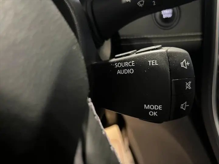 Gros plan sur la commande audio au volant du Renault Scenic IV DCI 160 Energy, intérieur noir.