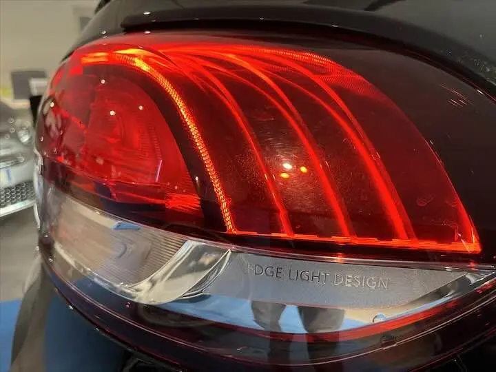 Gros plan sur le feu arrière droit rouge du Renault Scenic IV noir étoile métal avec inscription Edge Light Design.