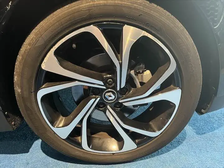 Gros plan sur la jante noire et argentée du Renault Scenic IV DCI 160 Energy, soulignant son design moderne.