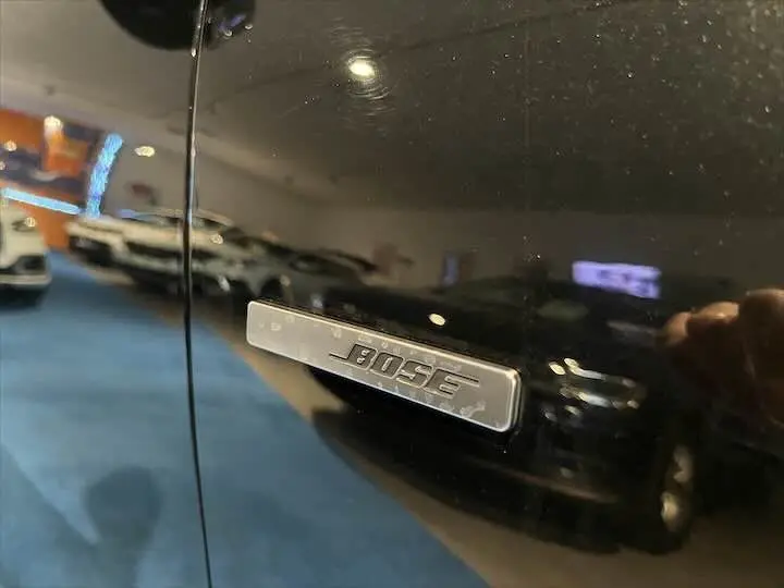 Gros plan sur l'emblème Bose sur la porte noire étoile métal du Renault Scenic IV DCI 160 Energy EDC Intens.