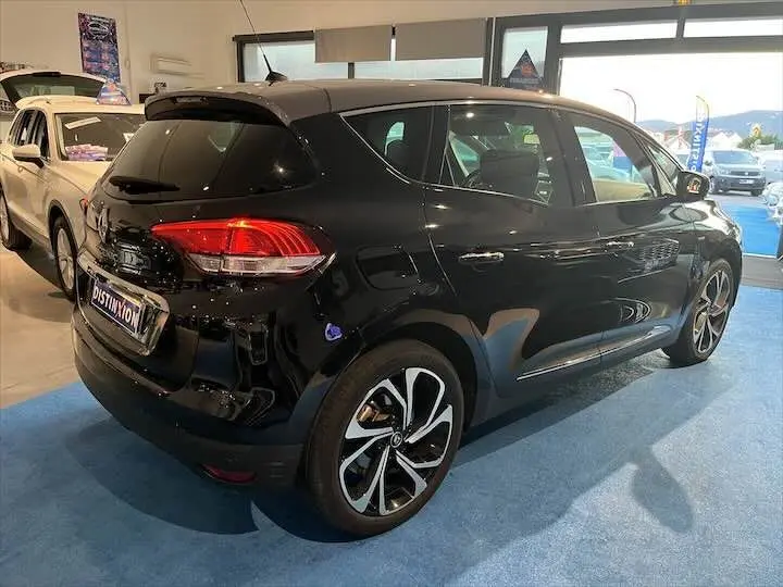 Renault Scenic IV DCI 160 Energy Intens noir étoile métal avec toit gris, vue 3/4 arrière droit en intérieur showroom.