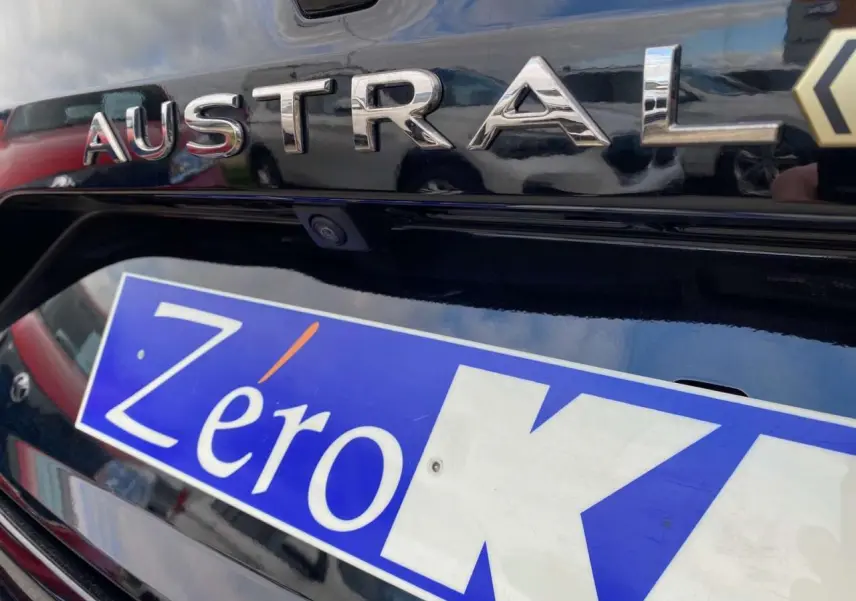 Gros plan sur le hayon arrière noir étoilé du Renault Austral E-Tech Full Hybrid avec logo et caméra de recul visible.