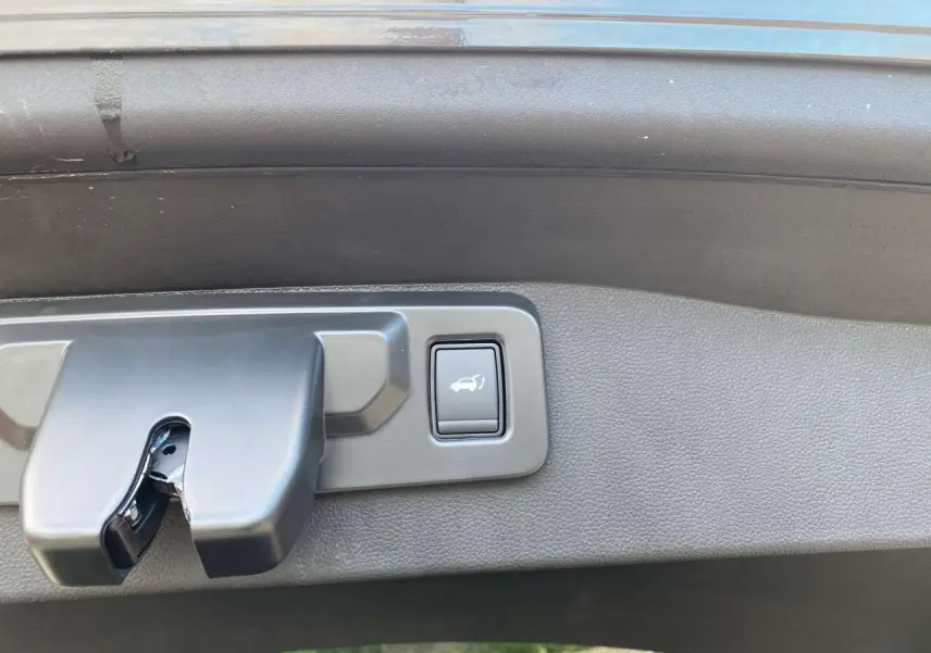 Bouton d'ouverture mains-libres du hayon motorisé sur le coffre d'un Renault Austral noir étoilé 2025.