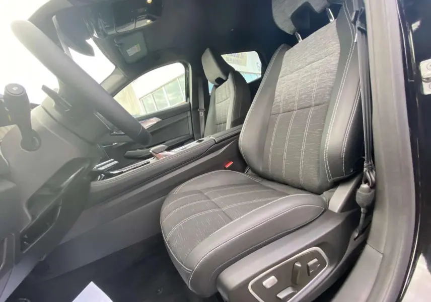 Vue intérieure côté conducteur du Renault Austral 2025 noir étoilé, siège avant en tissu et cuir avec réglages électriques.
