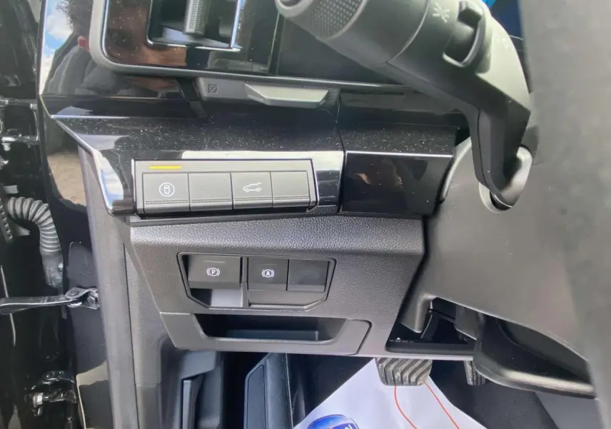 Vue rapprochée des commandes sous le tableau de bord côté gauche du Renault Austral Noir Étoile 2025 hybride.