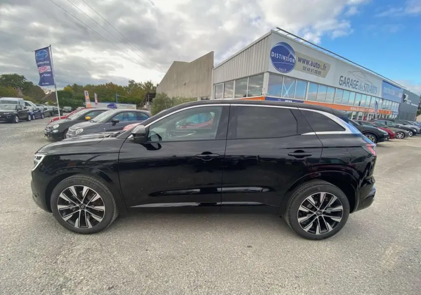 Profil côté gauche du Renault Austral 2025 noir étoilé avec jantes alliage noires et diamantées sur parking extérieur.