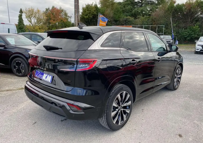 Vue 3/4 arrière droite du Renault Austral noir étoilé avec jantes alliage noires diamantées sur parking extérieur.