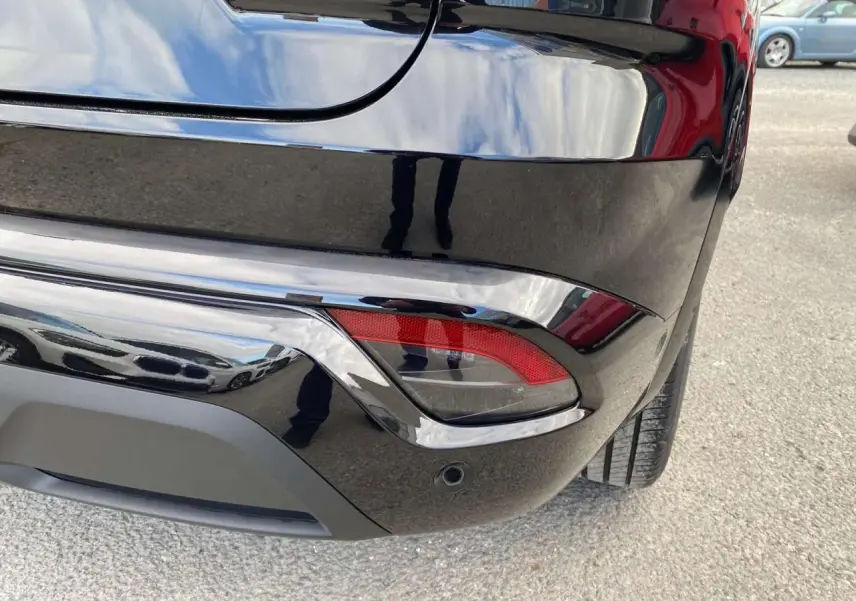 Gros plan sur le coin arrière droit du Renault Austral noir étoilé, mettant en valeur le feu arrière et le pare-chocs lustré.