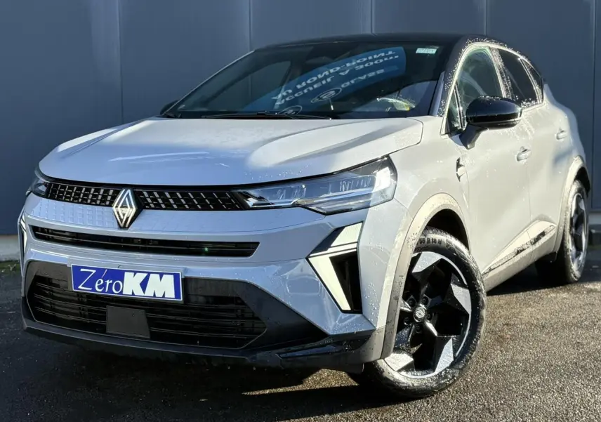 Renault Captur 2025 gris Rafale et noir, vue 3/4 avant droit, jantes noires et calandre moderne lumineuse.