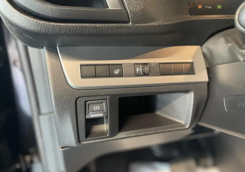 Gros plan sur les commandes à gauche du volant de l’Opel Vivaro 2025 noir carbone, avec bouton de frein à main électrique.