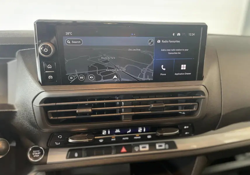 Vue rapprochée du tableau de bord de l'Opel Vivaro 2025, écran tactile avec navigation et commandes climatisation.