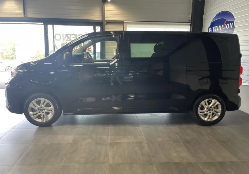 Vue de profil côté gauche d’un Opel Vivaro noir carbone 2025 en intérieur avec jantes alliage argentées.