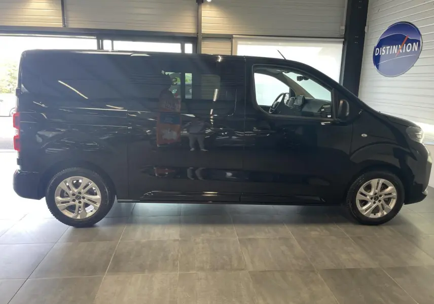 Vue latérale droite d'un Opel Vivaro noir carbone avec vitres surteintées et jantes alliage en showroom.