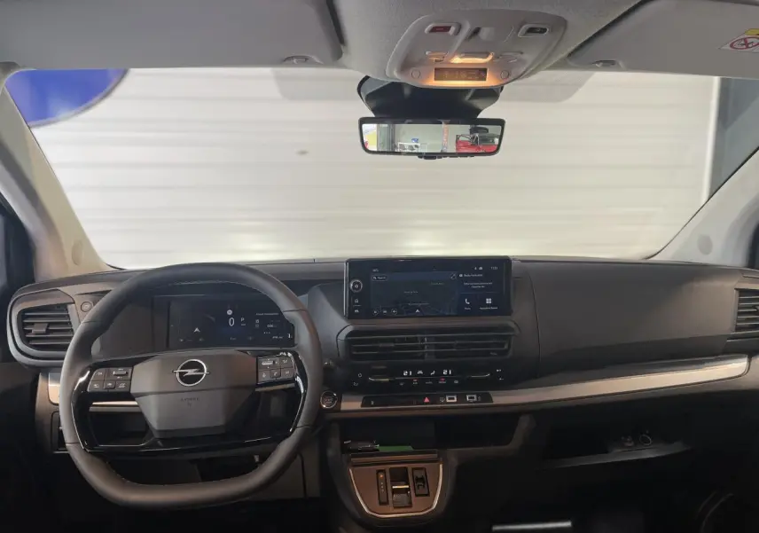 Vue frontale de l’habitacle noir du nouvel Opel Vivaro 2025, avec tableau de bord numérique et écran tactile central.