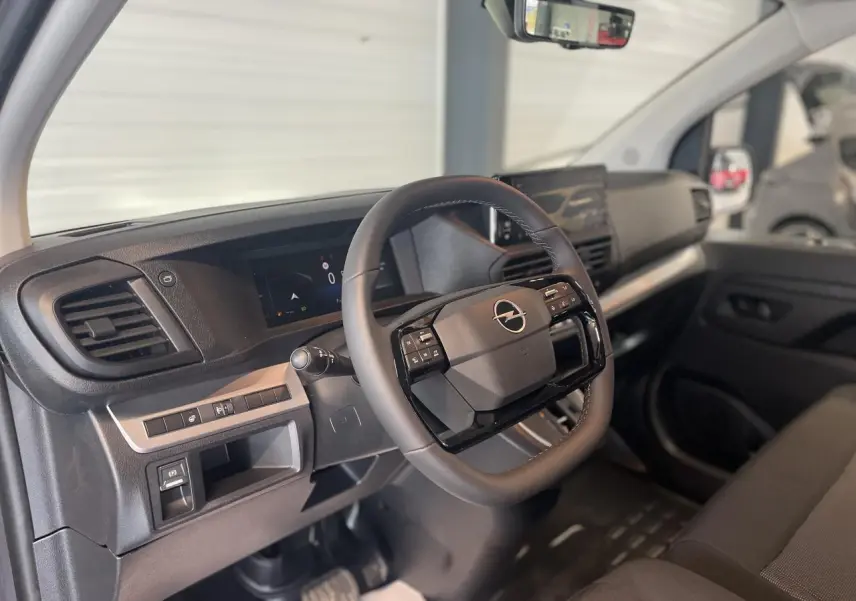 Vue intérieure côté conducteur de l'Opel Vivaro 2025, volant multifonction noir et tableau de bord moderne.