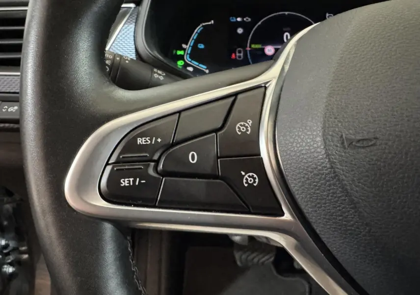 Gros plan sur les commandes de régulateur de vitesse au volant cuir noir du Renault Arkana Business E-TECH 145 2022.