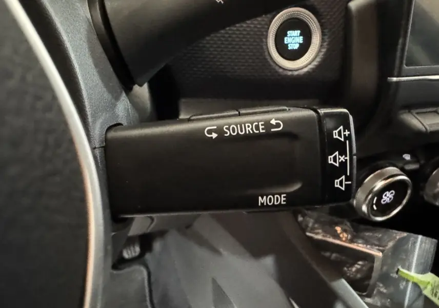 Gros plan sur la commande multimédia au volant du Renault Arkana Business E-TECH 145, avec bouton démarrage visible.