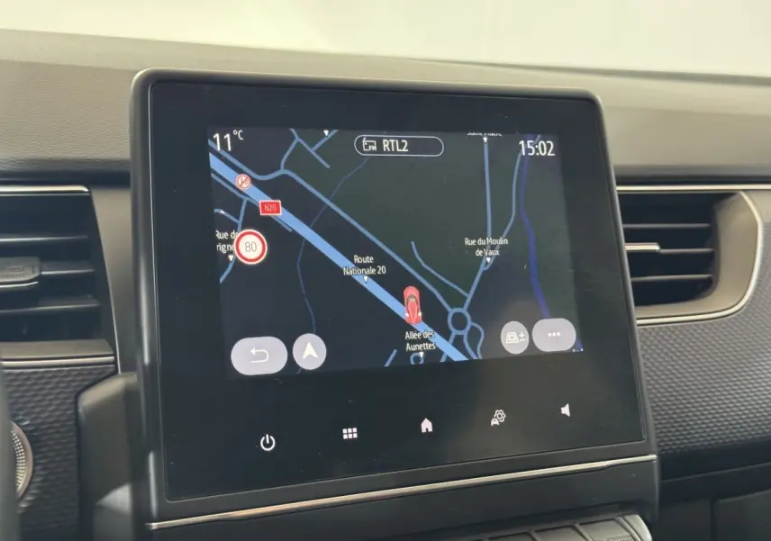 Écran tactile central affichant la navigation du Renault Arkana Business E-TECH 145, intérieur gris foncé.