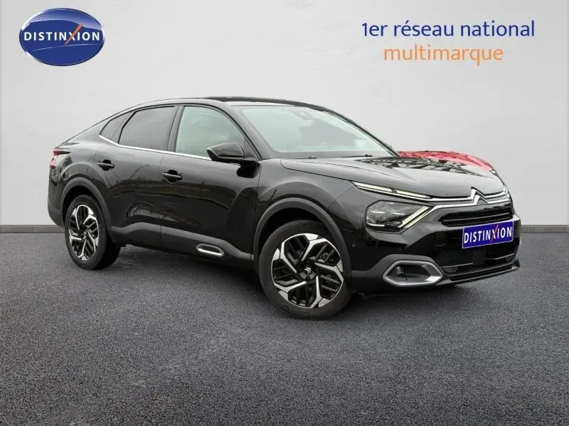 Citroën C4 X 2024 noir Perla Nera vue 3/4 avant droit, avec signature lumineuse distinctive et jantes stylées.