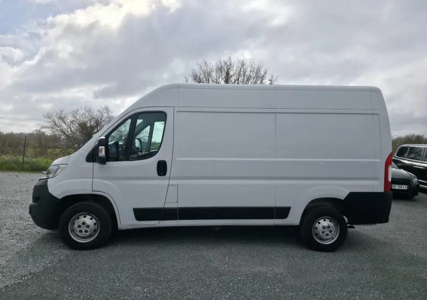 Vue de profil côté gauche d’un Opel Movano Fourgon blanc 2022 avec portes latérale et arrière tôlées, jantes tôle 15 pouces grises.