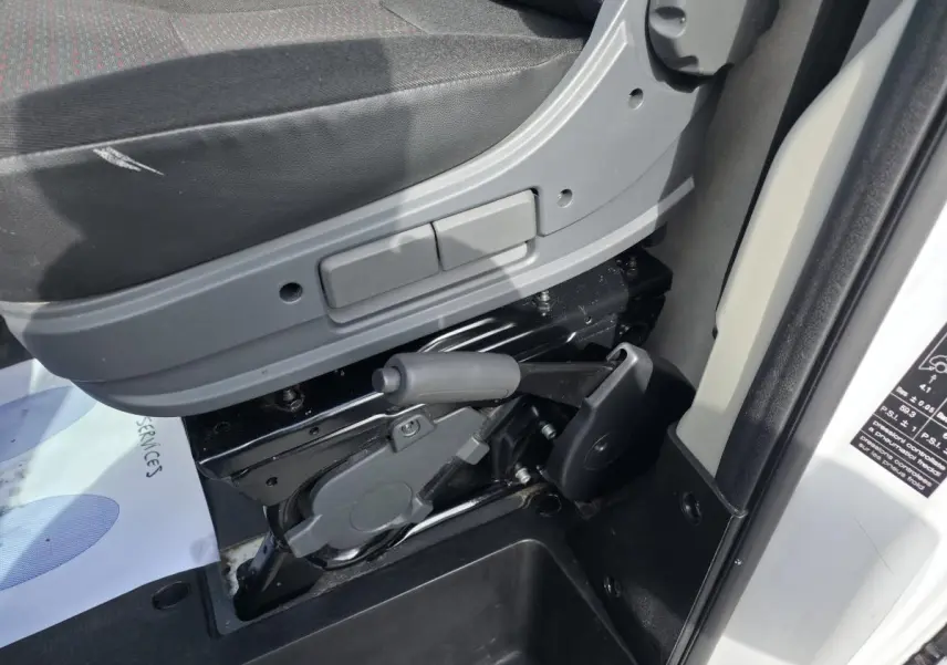 Gros plan côté gauche sur le levier de frein à main et la base du siège conducteur du fourgon blanc Opel Movano 2022.
