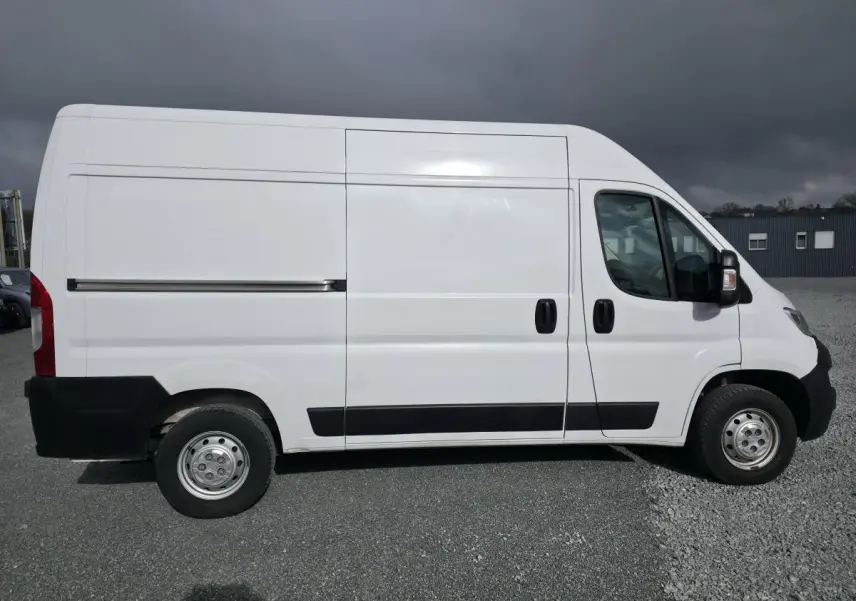 Vue de profil droit de l'Opel Movano Fourgon blanc 2022 avec portes latérales coulissantes et jantes tôles grises.