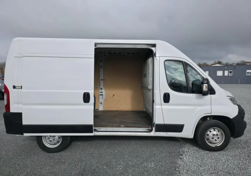 Vue latérale droite d’un Opel Movano Fourgon blanc 2022 avec porte coulissante ouverte montrant l’espace de chargement vide.