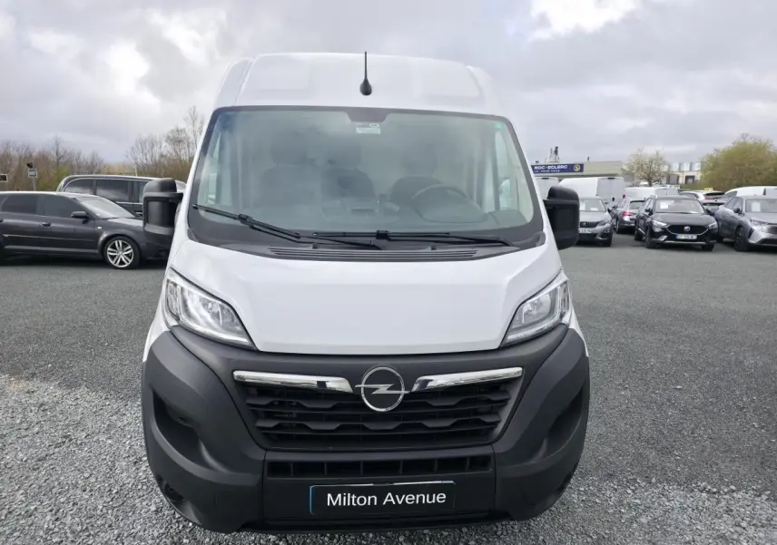 Vue de face d’un Opel Movano Fourgon blanc avec calandre noire et logo Opel bien visible.