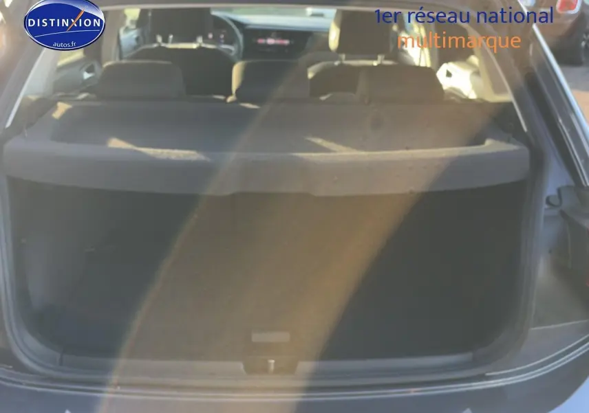 Vue arrière ouverte du coffre d'une Volkswagen Polo gris, mettant en valeur l'espace de chargement et la tablette cache-bagages.