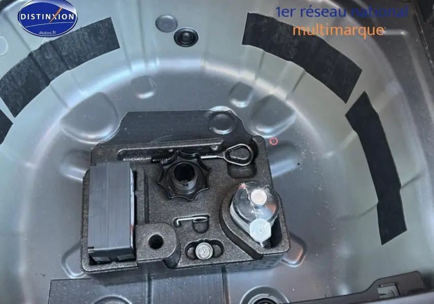 Vue plongeante sur le rangement de roue de secours gris d'une Volkswagen Polo 2025 avec outils intégrés.