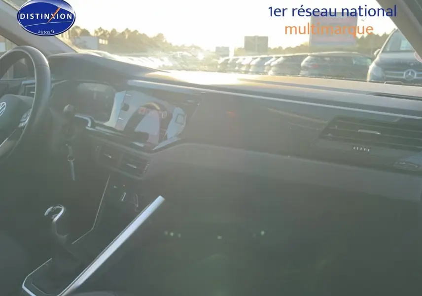 Vue intérieure côté conducteur d'une Volkswagen Polo 2025 gris, avec tableau de bord moderne et écran tactile.