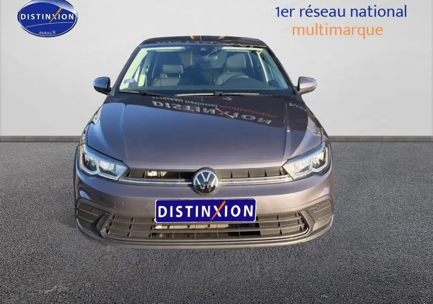 Vue frontale d'une Volkswagen Polo gris métallisé avec calandre noire et phares LED, sur fond neutre.