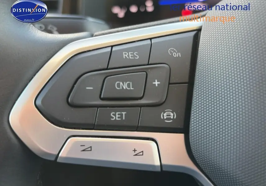 Gros plan sur les commandes multifonctions du volant cuir de la Volkswagen Polo gris 2025, version 1.0 TSI 95 VW Edition.