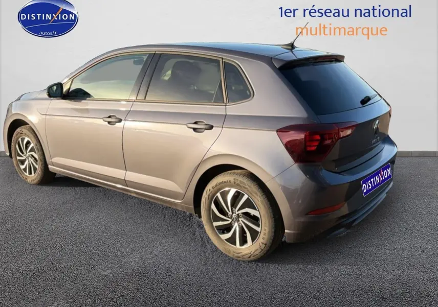 Volkswagen Polo gris vue 3/4 arrière côté droit avec jantes alliage et vitres arrière surteintées.