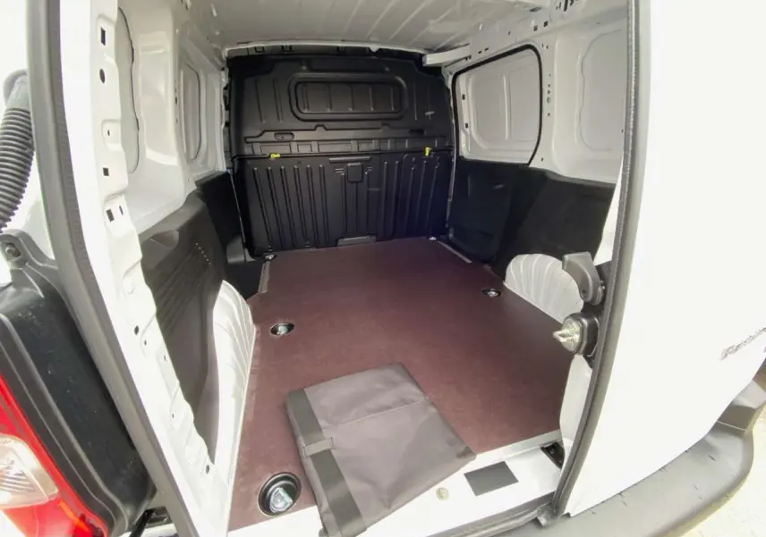 Vue intérieure arrière du Citroën Berlingo blanc 2026, montrant l’espace de chargement avec plancher bois antidérapant.
