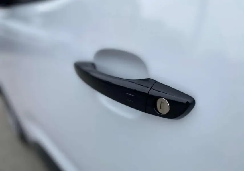 Poignée de porte noire brillante en gros plan sur la portière blanche d'un Citroën Berlingo 2026.