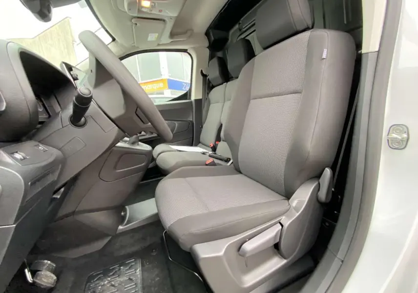 Vue intérieure côté conducteur du Citroën Berlingo blanc 2026, montrant les sièges gris et le tableau de bord.