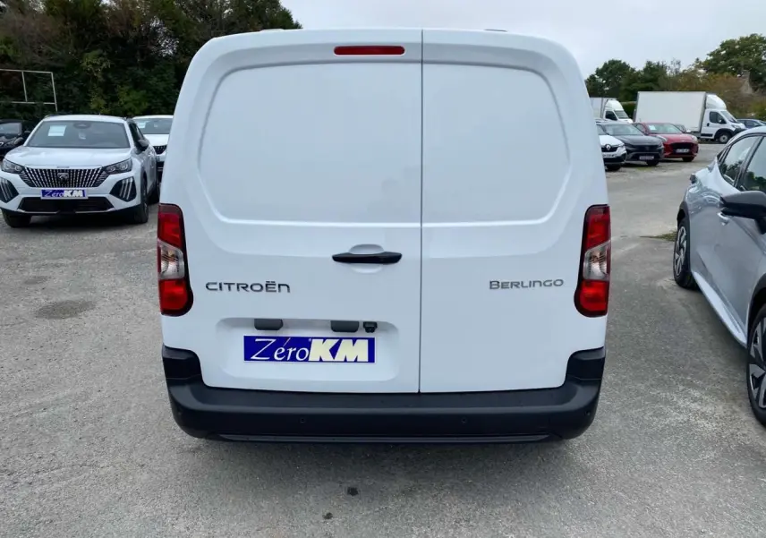 Vue arrière d’un utilitaire Citroën Berlingo blanc avec portes battantes et pare-chocs noir mat.