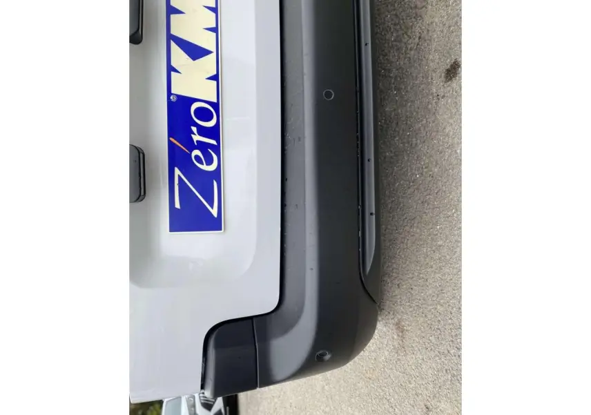 Gros plan sur le pare-chocs arrière noir et la partie basse blanche du Citroën Berlingo 2026, avec plaque "Zéro KM".
