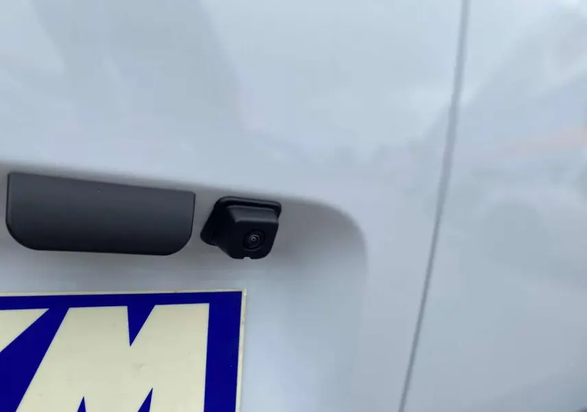 Gros plan sur la caméra de recul noire intégrée au hayon arrière blanc du Citroën Berlingo 2026.