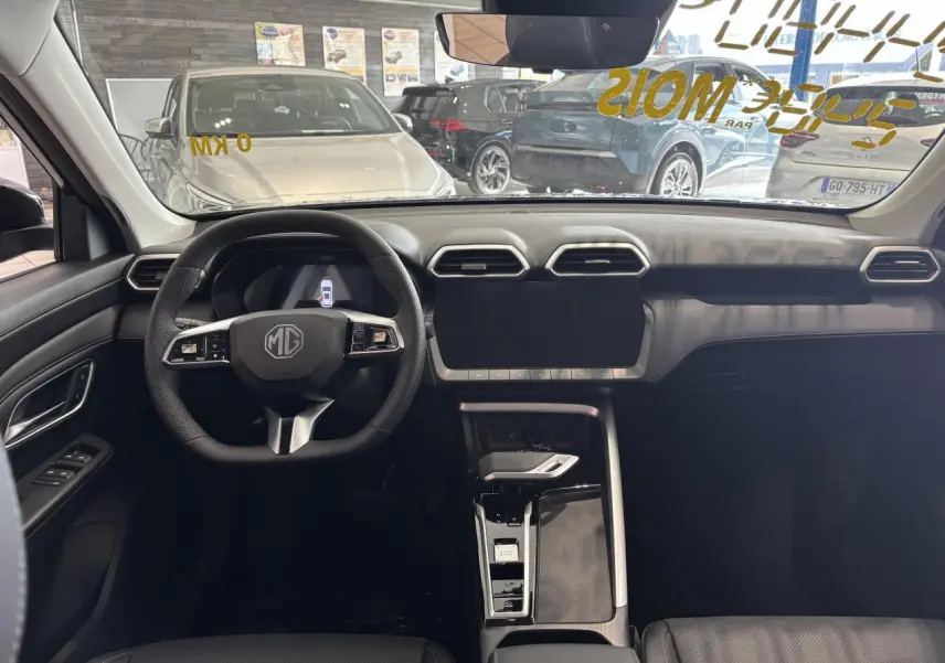 Vue intérieure avant du MG ZS 1.5 Hybrid+ noir, tableau de bord moderne avec écran tactile et volant multifonction.