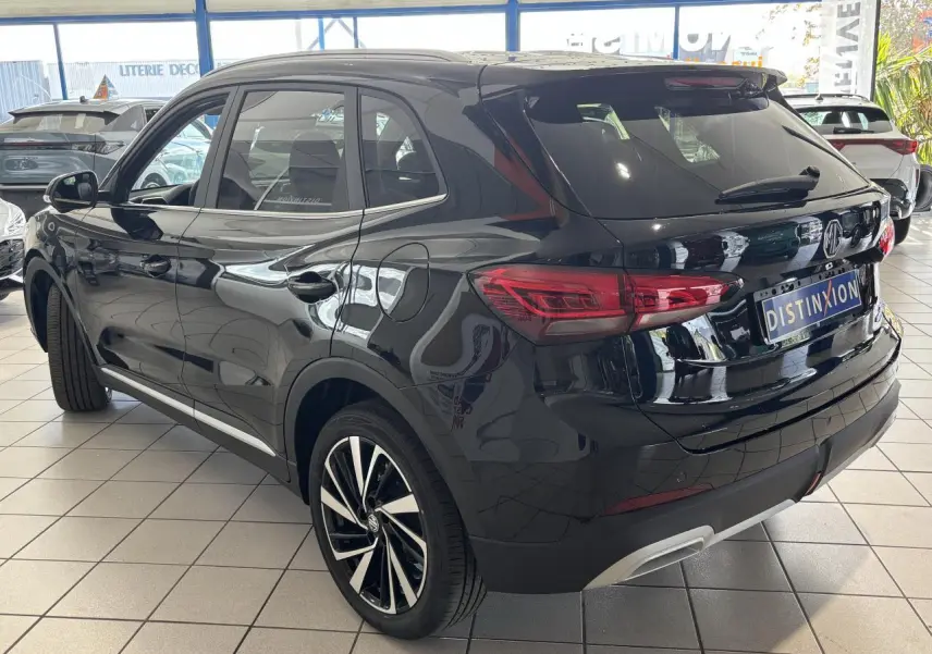 MG ZS 1.5 Hybrid+ noir métallisé vu en 3/4 arrière droit, avec jantes alliage 18 pouces et vitres surteintées.