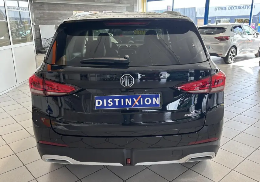Vue arrière d'un MG Motor ZS 1.5 Hybrid+ noir, avec feux LED et logo MG visible en concession.
