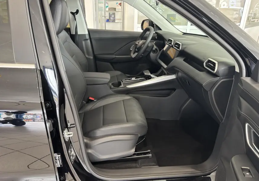Vue intérieure côté conducteur du MG Motor ZS 1.5 Hybrid+ noir, avec sellerie cuir/similicuir et tableau de bord moderne.