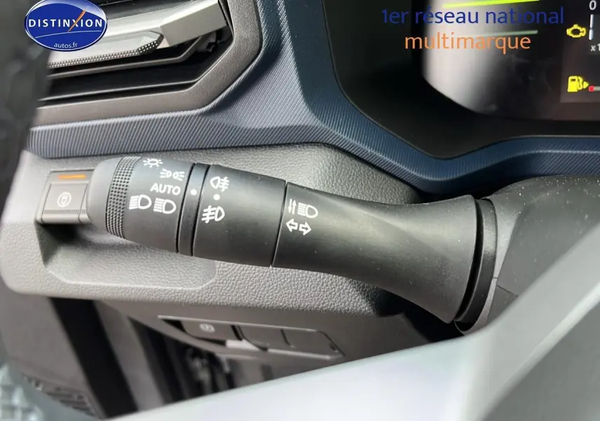 Gros plan sur la commande des phares et clignotants du tableau de bord du Dacia Duster gris schiste 2025.