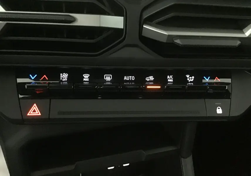 Panneau de commande de climatisation automatique du Dacia Bigster 2025 en gros plan, avec voyants lumineux et boutons tactiles.