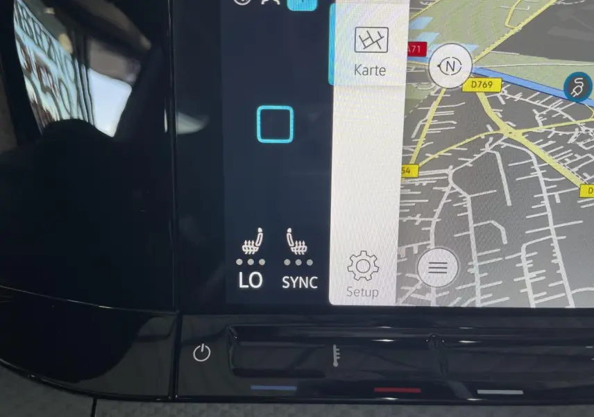 Écran tactile du système de navigation et climatisation digitale de la Volkswagen Golf rouge métal, vue intérieure rapprochée.
