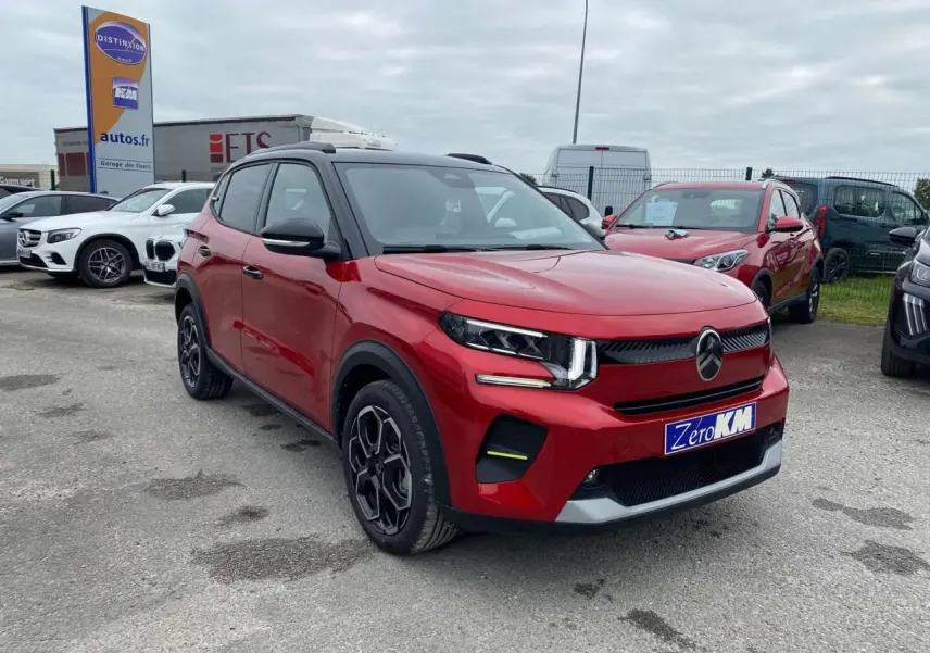 SUV Citroën C3 Turbo 100 CH rouge Elixir avec toit noir, vu en 3/4 avant droit sur parking extérieur.
